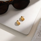 gold plated rounded dome earrings beside sunglasses