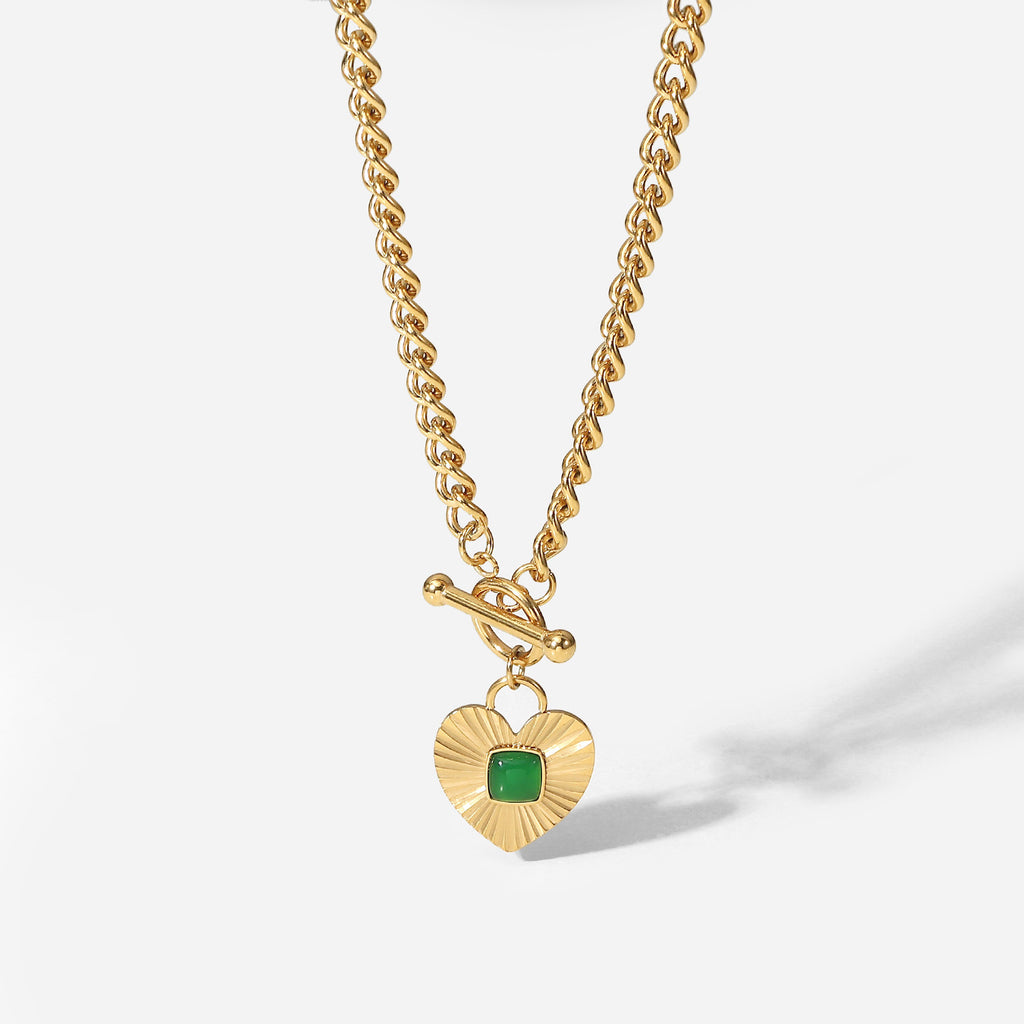 isolated chunky curb necklace with square green center stone