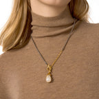 Silver-colored and gold-detail pendant necklace on a model