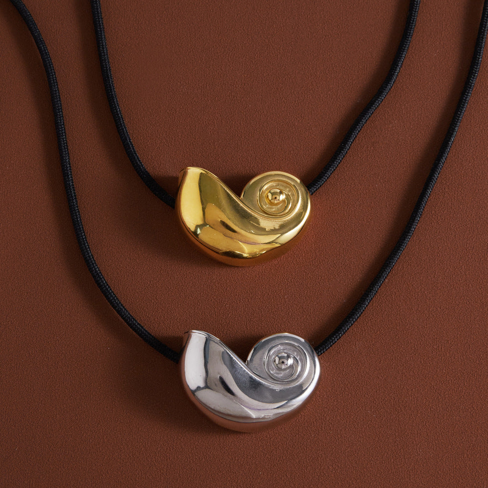 Gold tone and silver tone spiral shell pendants on black cords