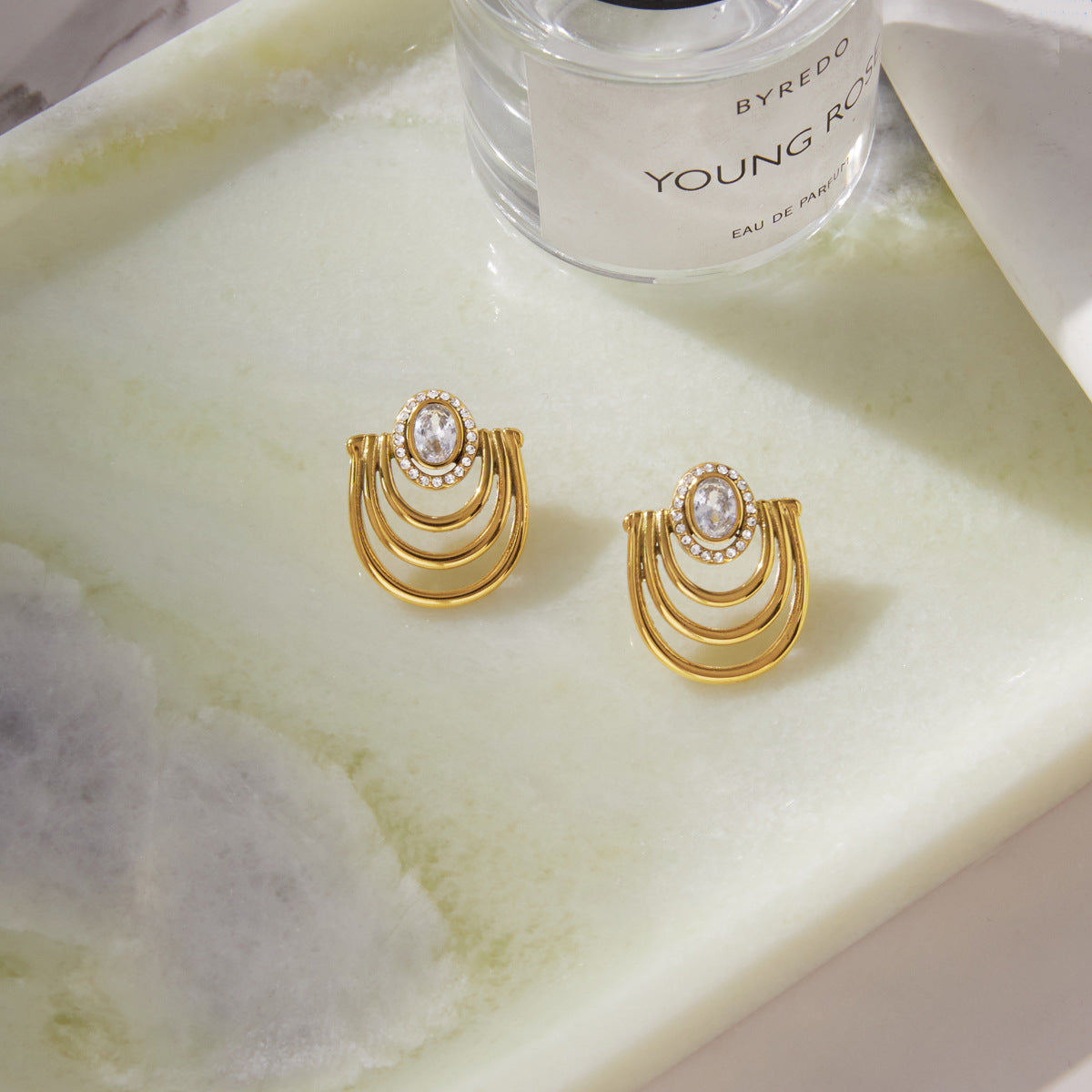 Gold tone arc earrings with oval stone centers