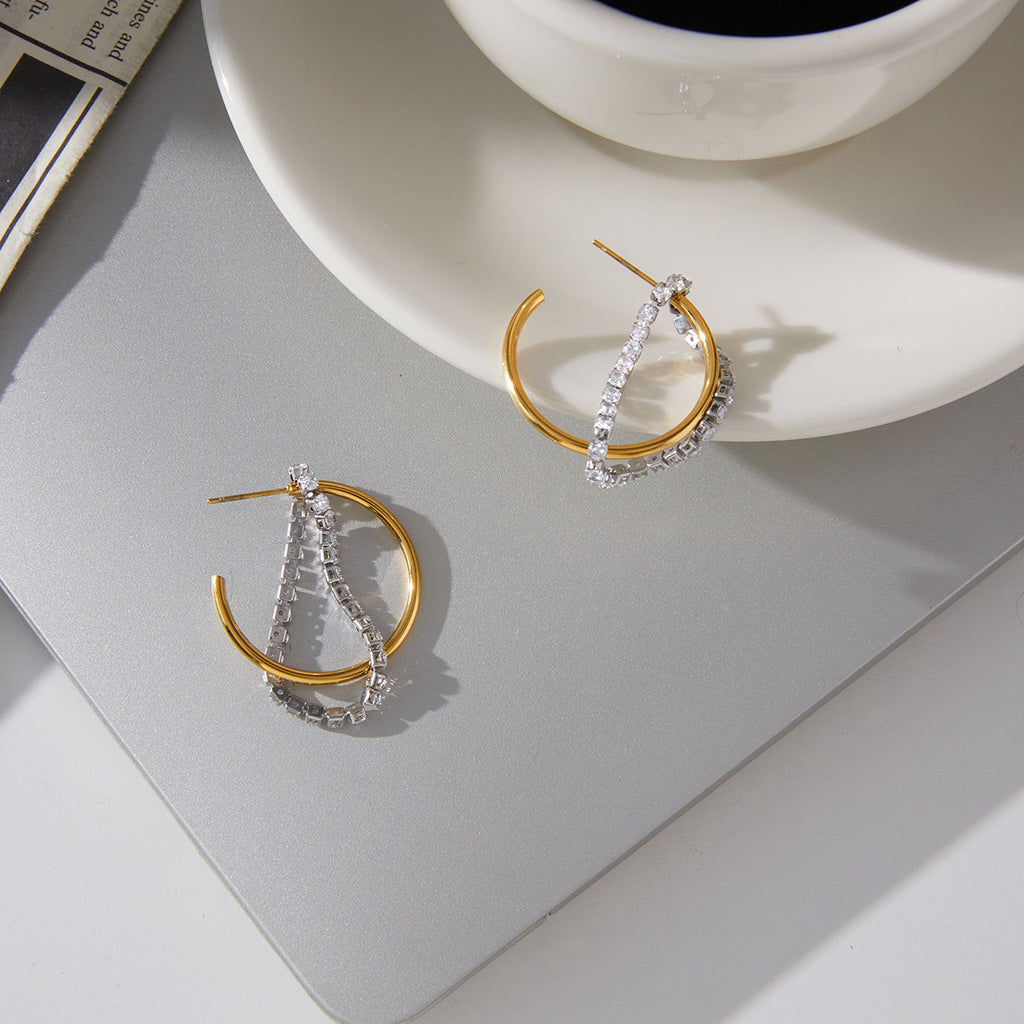 pair of two-tone clear stone tassel hoops on gray tray