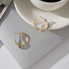 pair of two-tone clear stone tassel hoops on gray tray