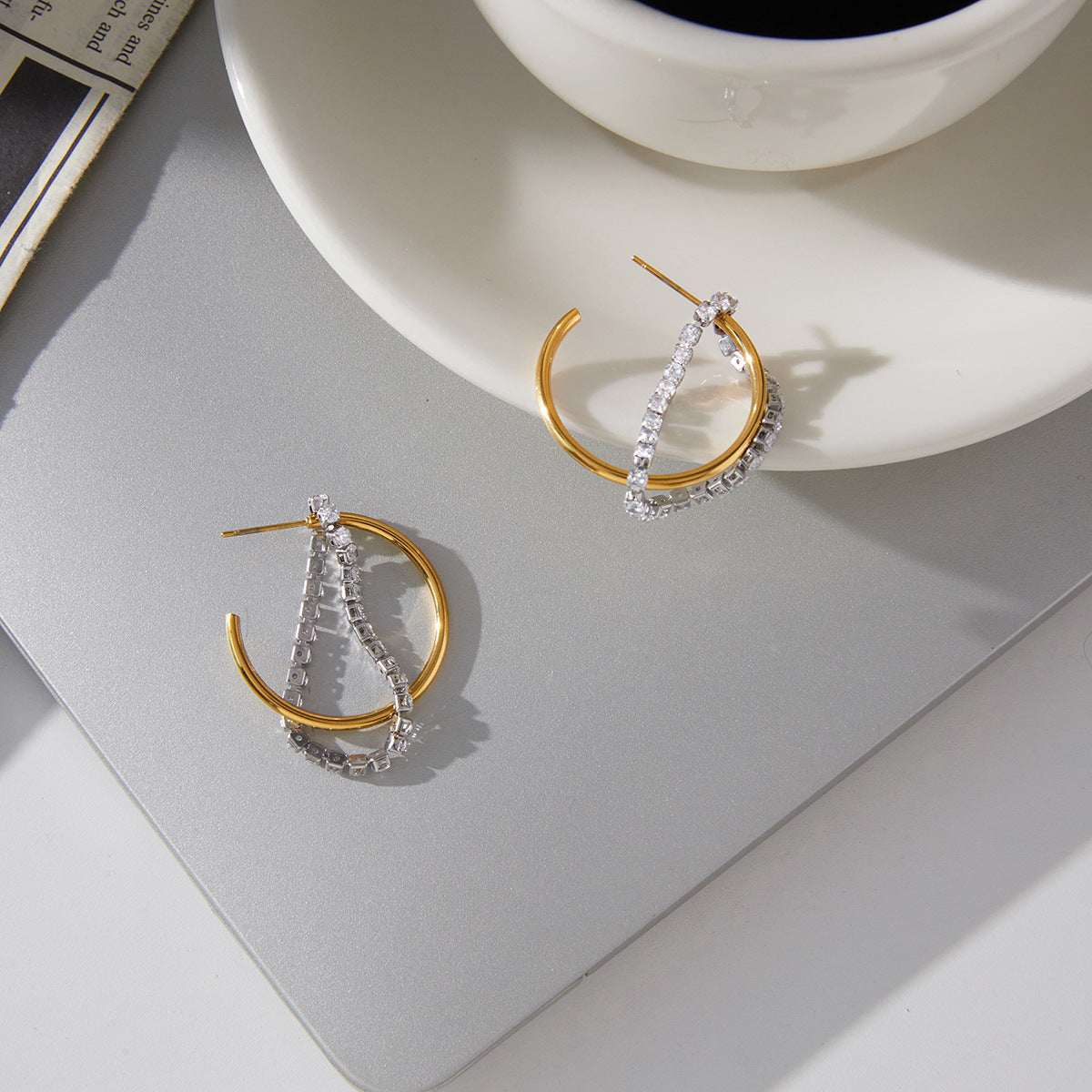 pair of two-tone clear stone tassel hoops on gray tray