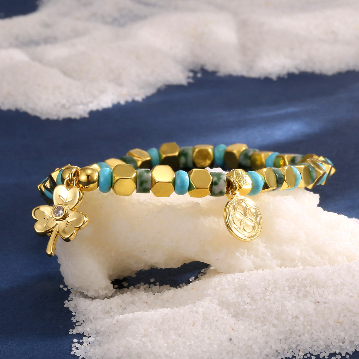 clover charm cube bead bracelet styled on white granules