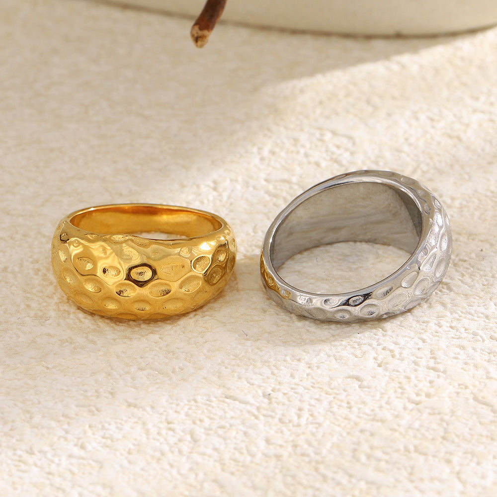 gold and silver textured dome rings displayed on stone