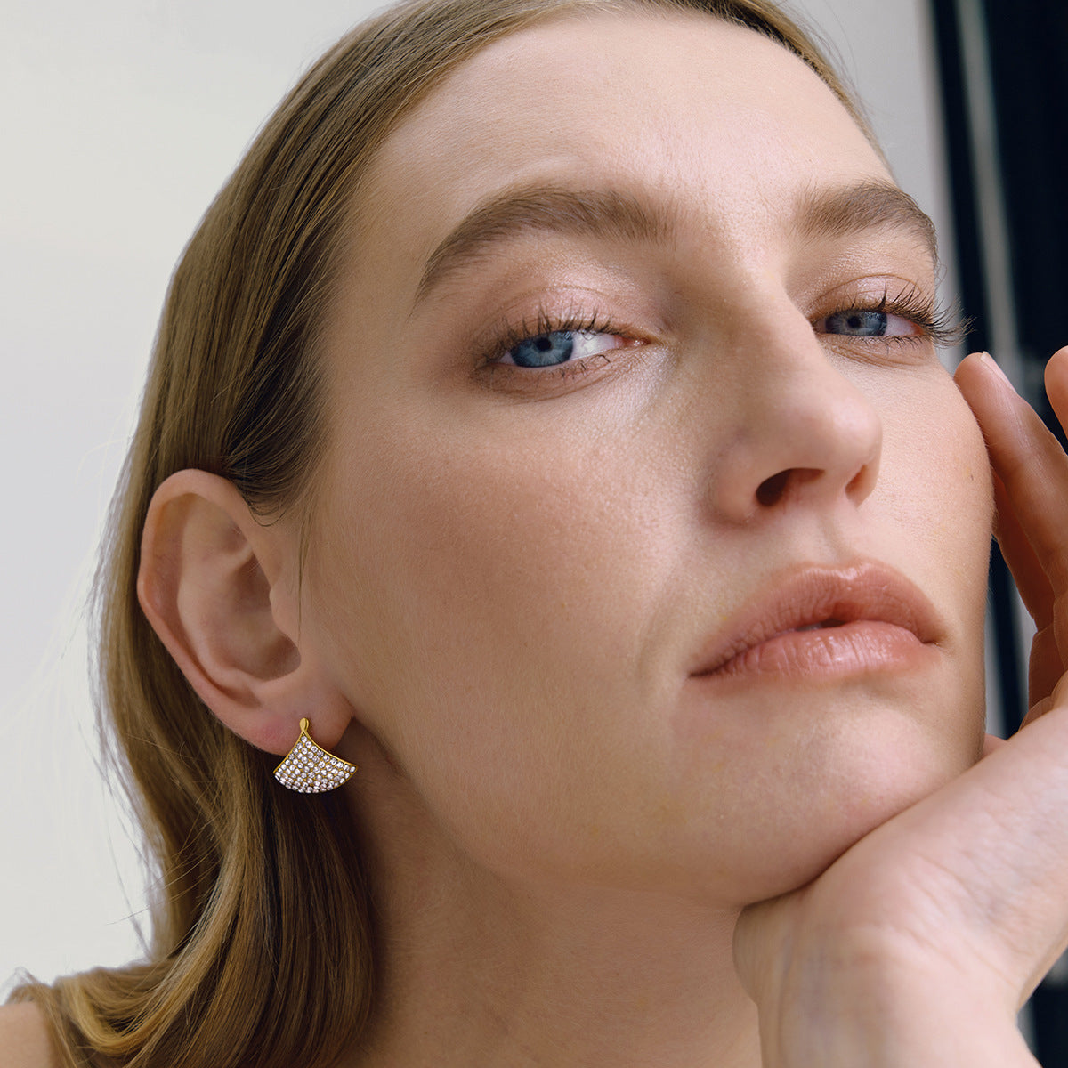 Gold-tone fan earring shown on model