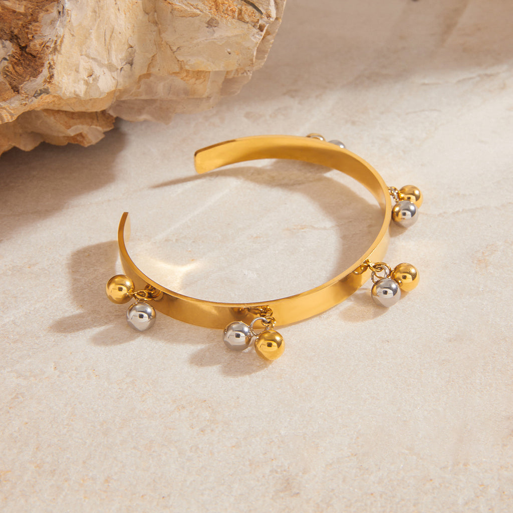 Side view of stainless steel ball fringe cuff on stone props