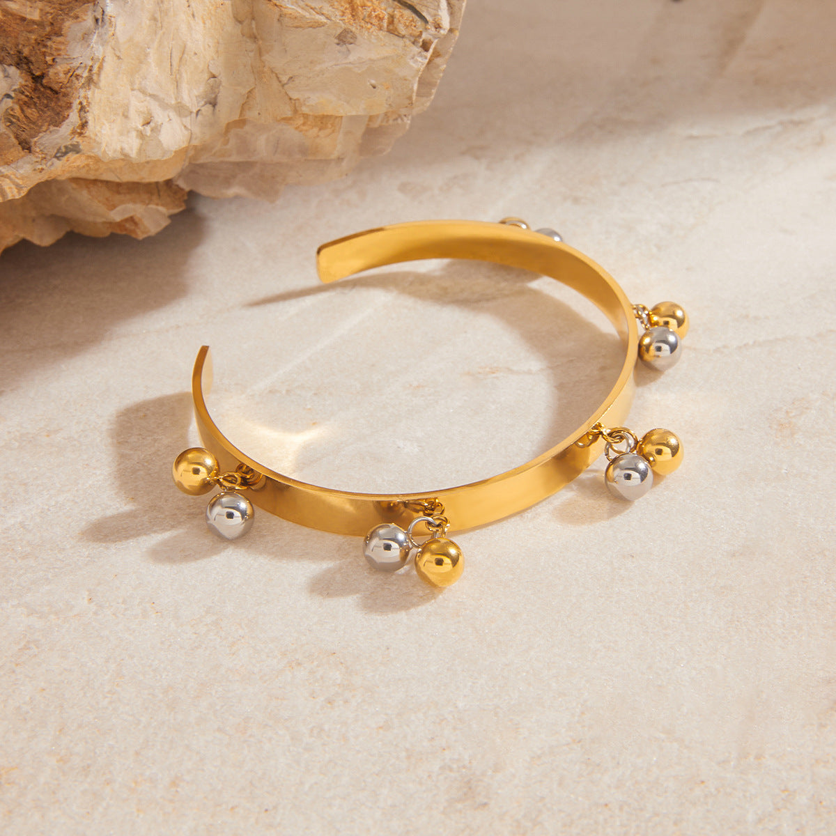 Side view of stainless steel ball fringe cuff on stone props