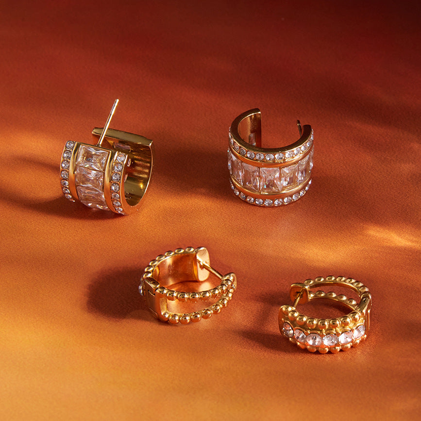 Two gold-tone hoop styles on orange fabric