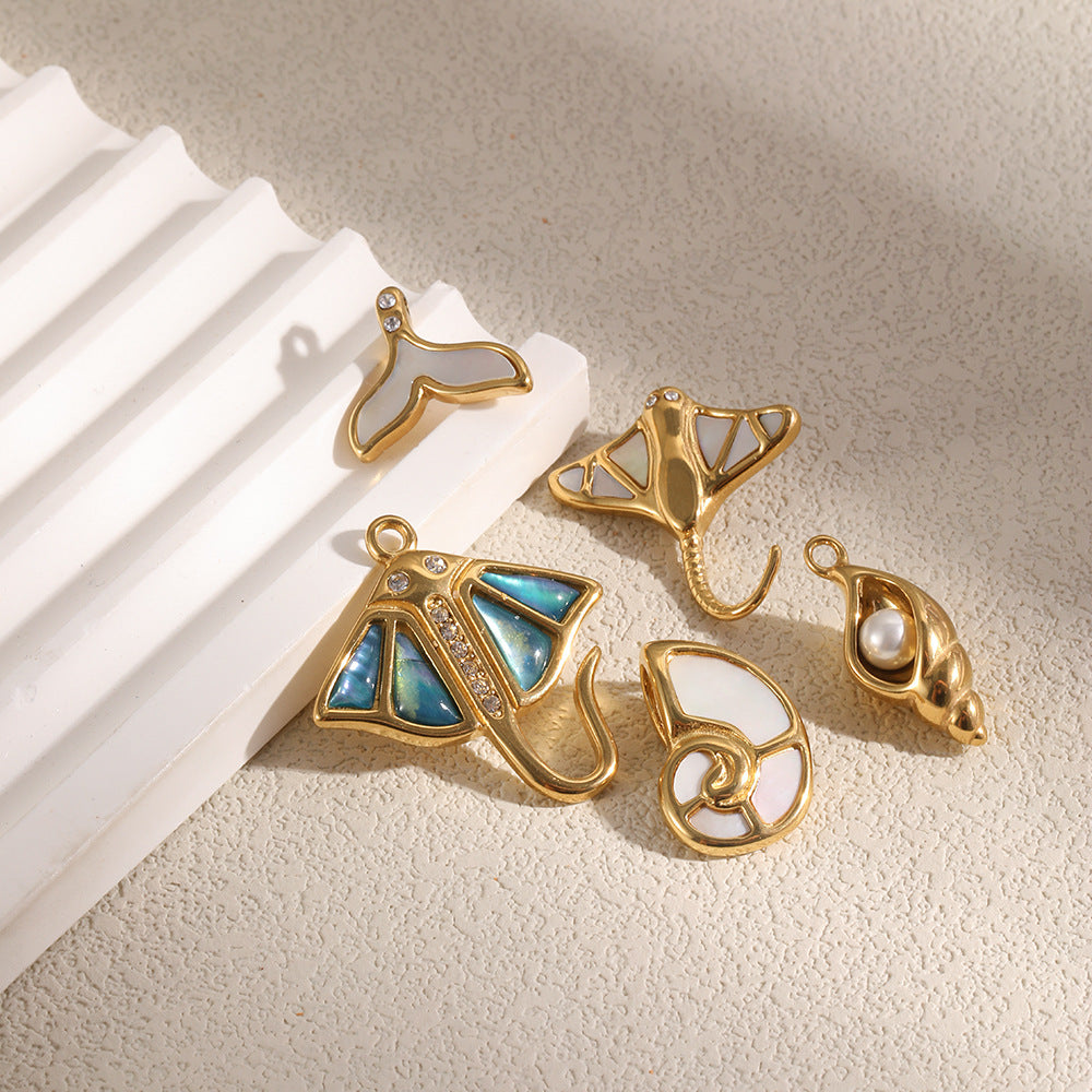 Shell, ray and whale-tail charms on stone