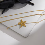 Gold tone chains and star pendant laid on a board
