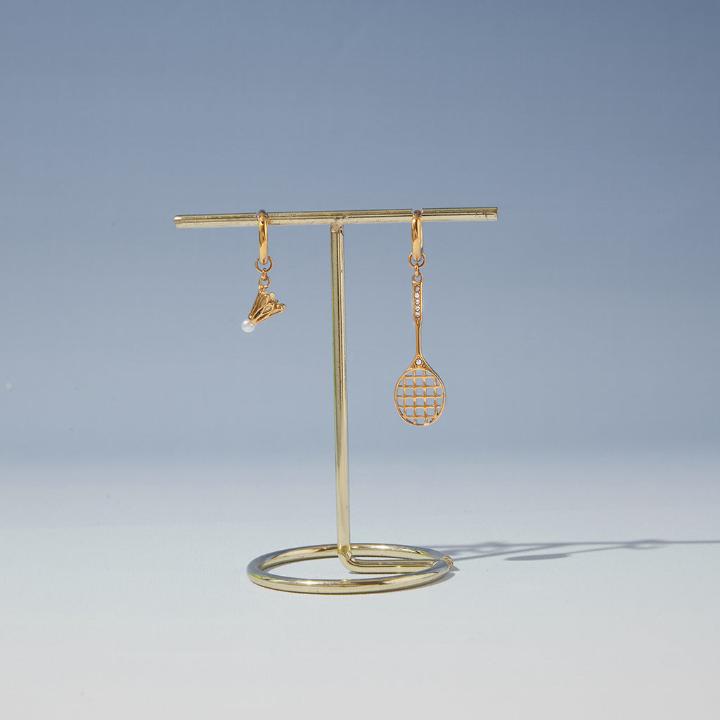 Racket and shuttlecock earrings hanging on a stand