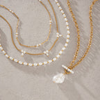 Imitation pearl strand and three chain necklaces on white
