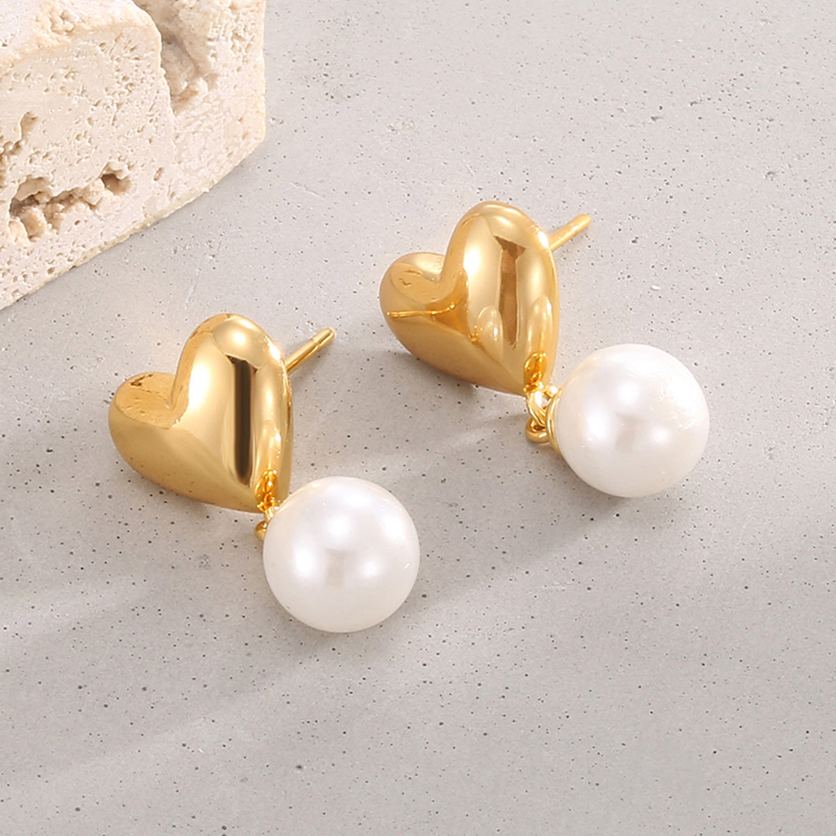 side view of heart stud earrings with single shell pearl drops