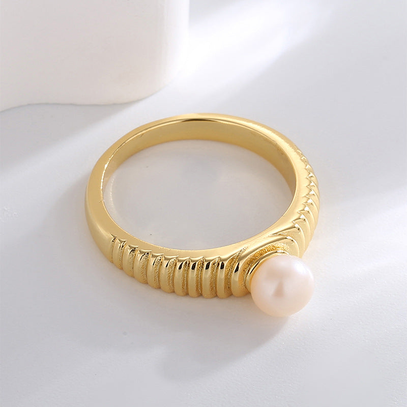side view of gold plated ring with raised white shell pearl