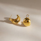 Round zirconia studs with domed gold tone bodies and visible backs