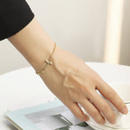 model wearing a slim cross curb chain bracelet