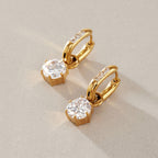 Gold-tone oval hoops and round drops shown at an angle