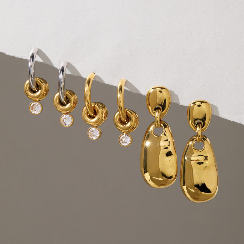 Gold and two-tone ring-accent hoops beside polished drop earrings