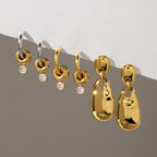 Gold and two-tone ring-accent hoops beside polished drop earrings