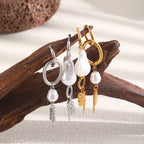 Gold and silver tone asymmetric earrings on driftwood