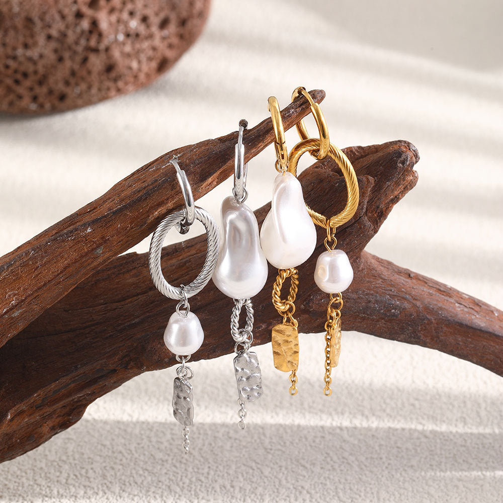 Gold and silver tone asymmetric earrings on driftwood