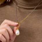 Two-tone toggle necklace with white drop worn over knitwear