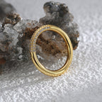 angled triple-row zirconia band ring beside natural stone
