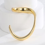 side view of sculptural brass wave bangle