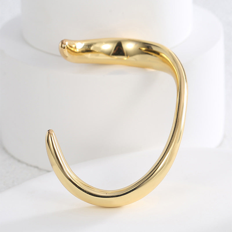 side view of sculptural brass wave bangle