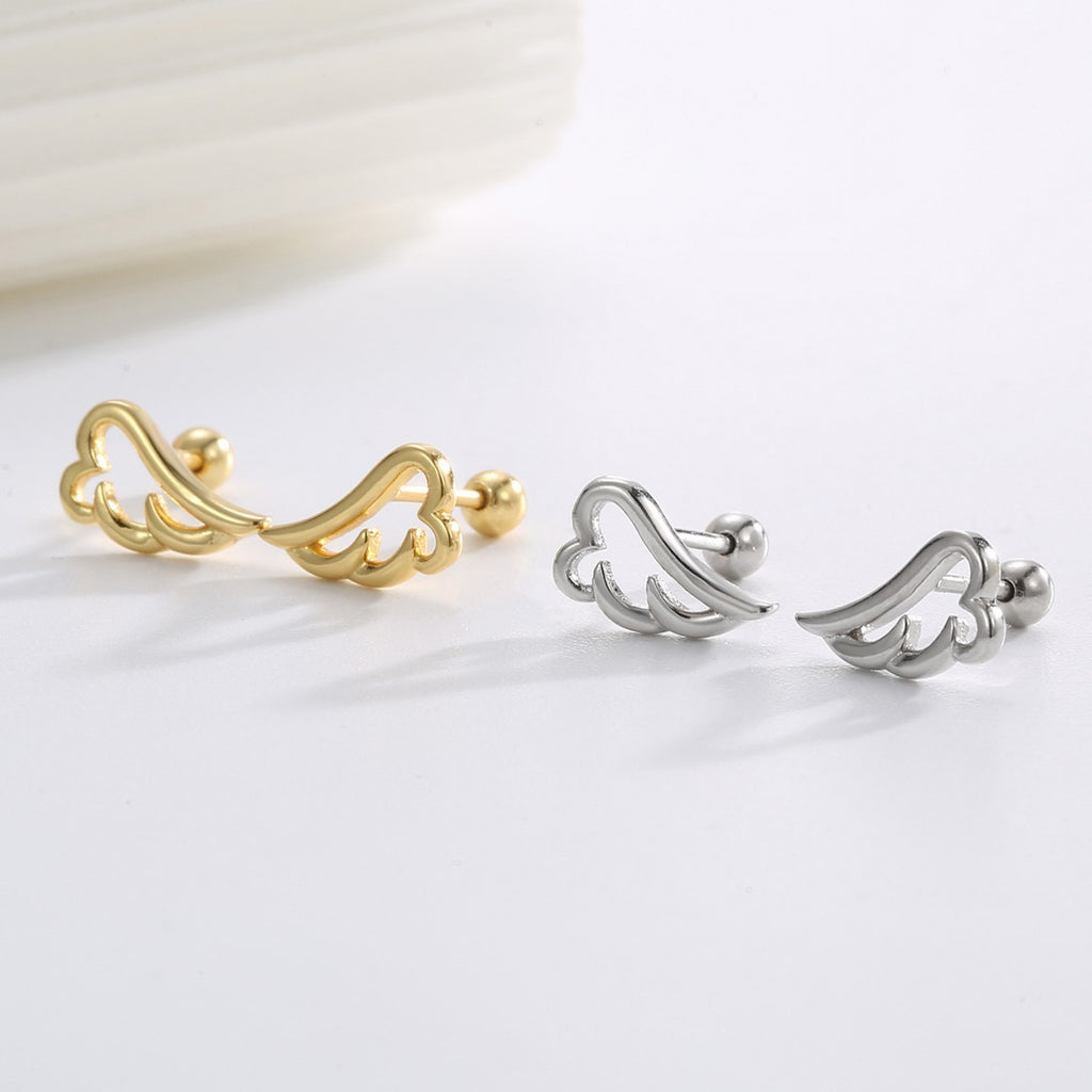 gold and silver angel wing stud earrings in a styled flat lay