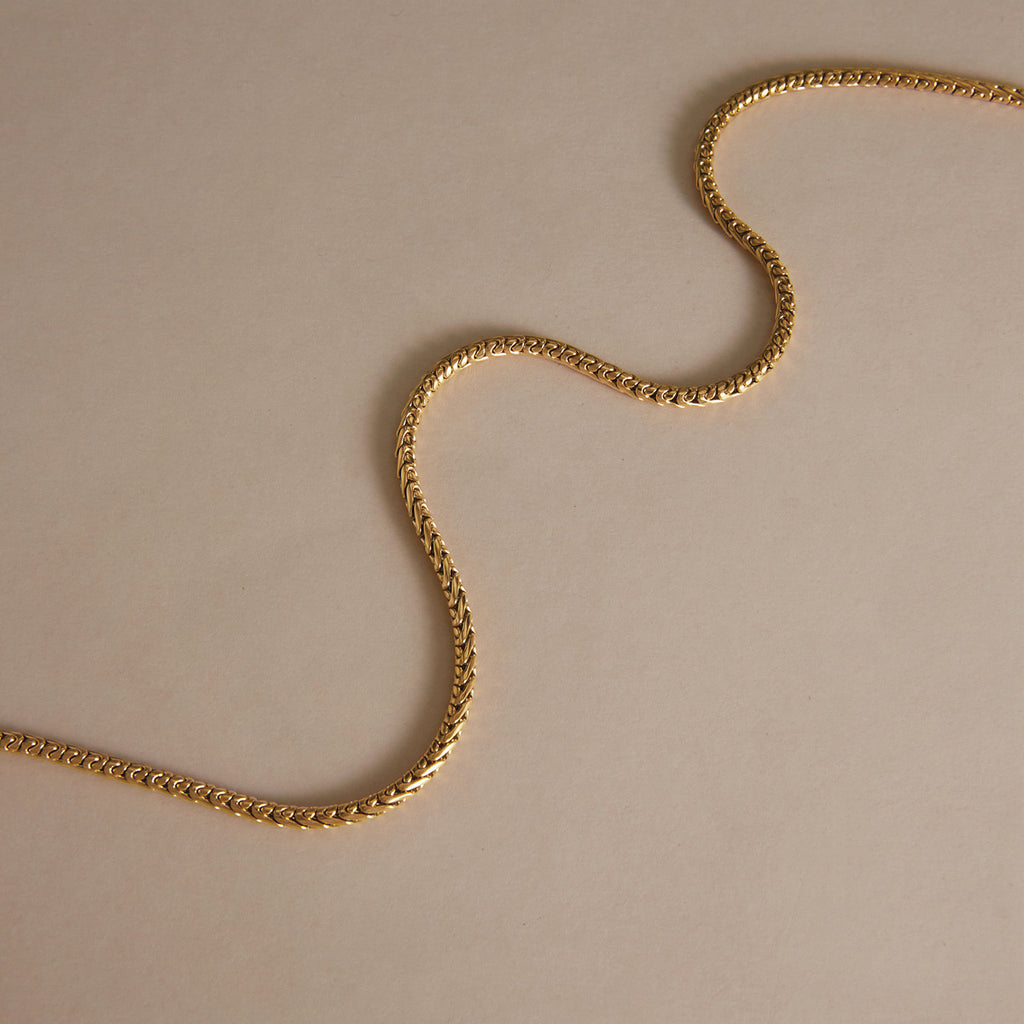 Close-linked necklace chain arranged in a soft curve