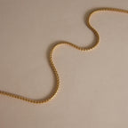 Close-linked necklace chain arranged in a soft curve