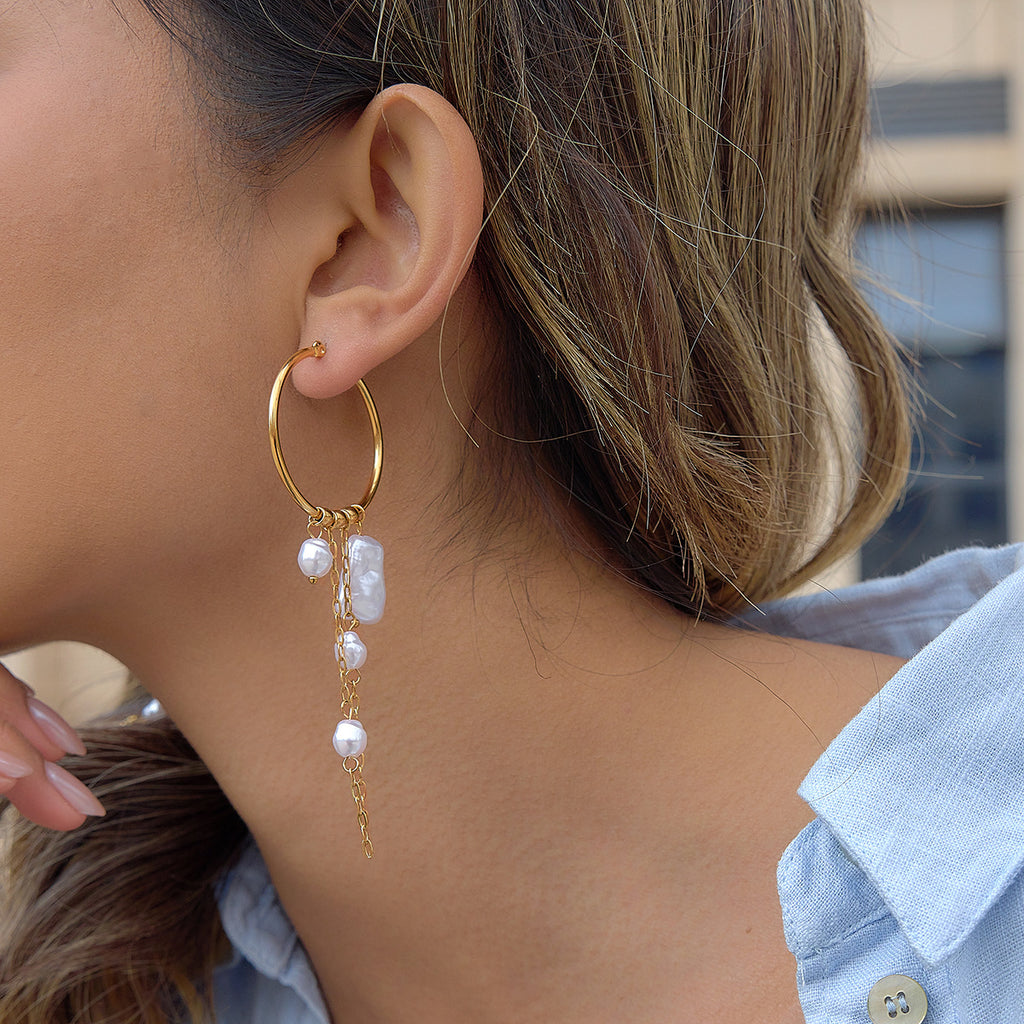 Front wearing view of the gold-finish hoop and hanging faux pearl chains