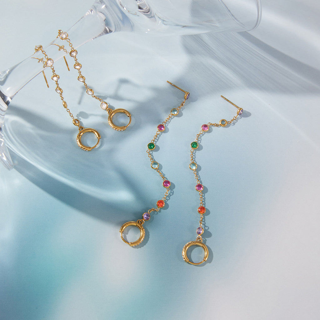 clear and multicolor rhinestone tassel earring pairs on glass