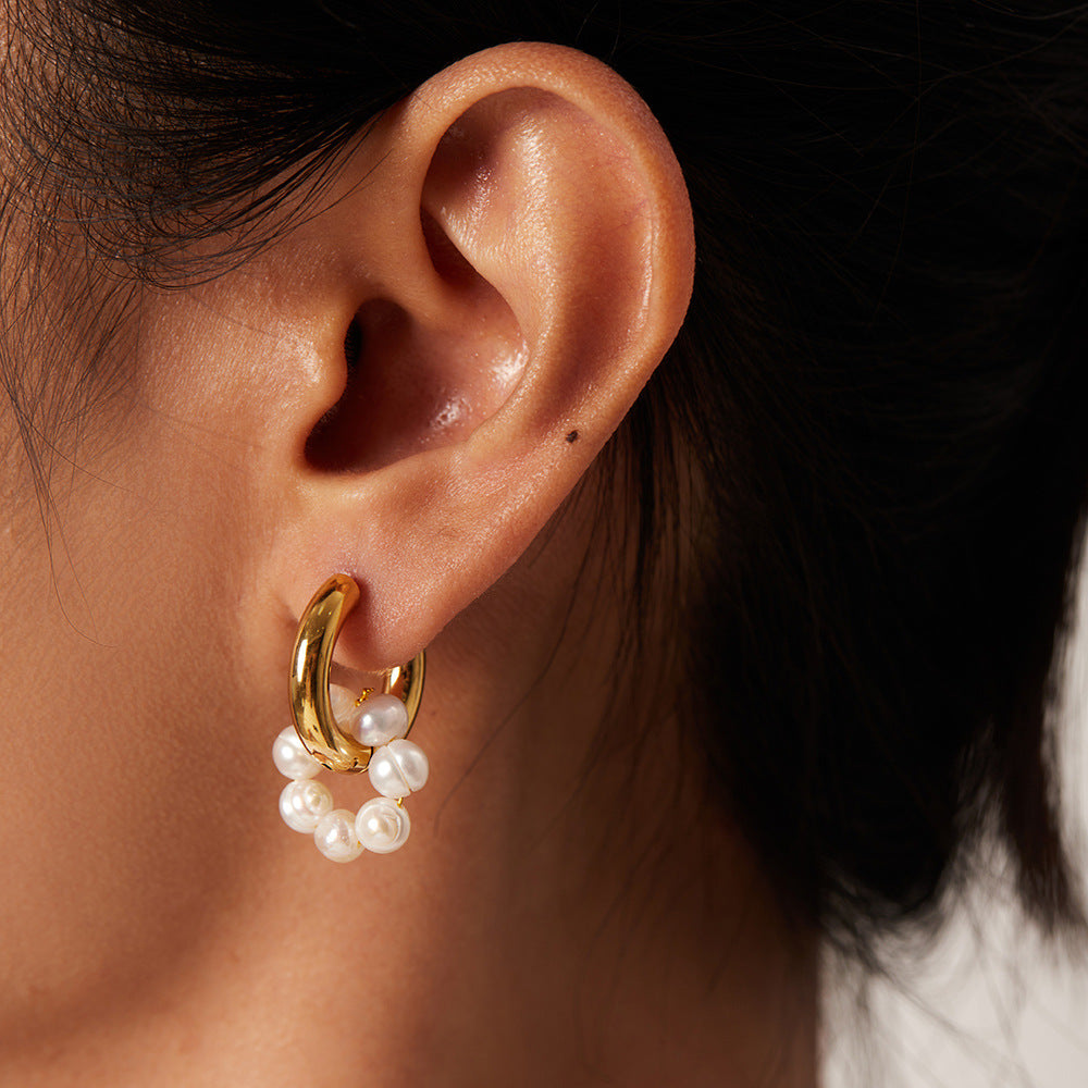 Gold-tone hoop with freshwater pearl loop worn on an ear