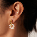 Gold-tone hoop with freshwater pearl loop worn on an ear