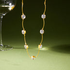 Station necklace suspended with clear round stones