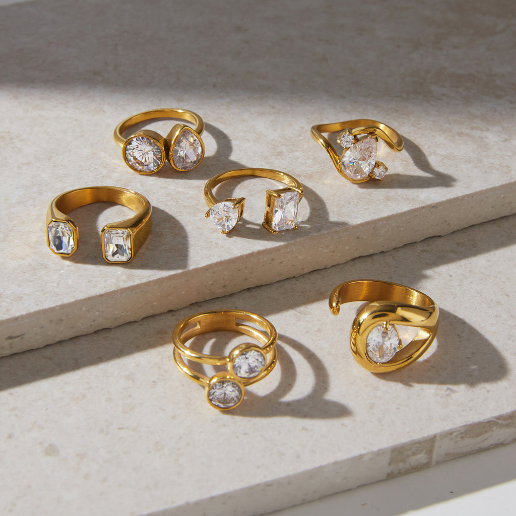 Asymmetric stainless steel ring assortment displayed on stone