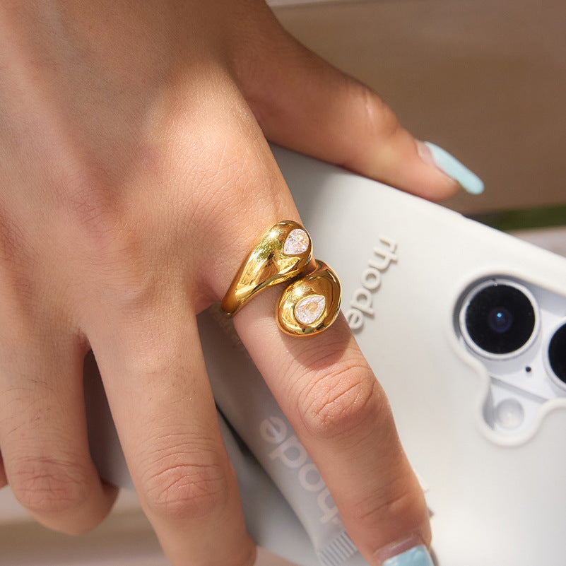 Rounded two-stone bypass ring close-up on hand