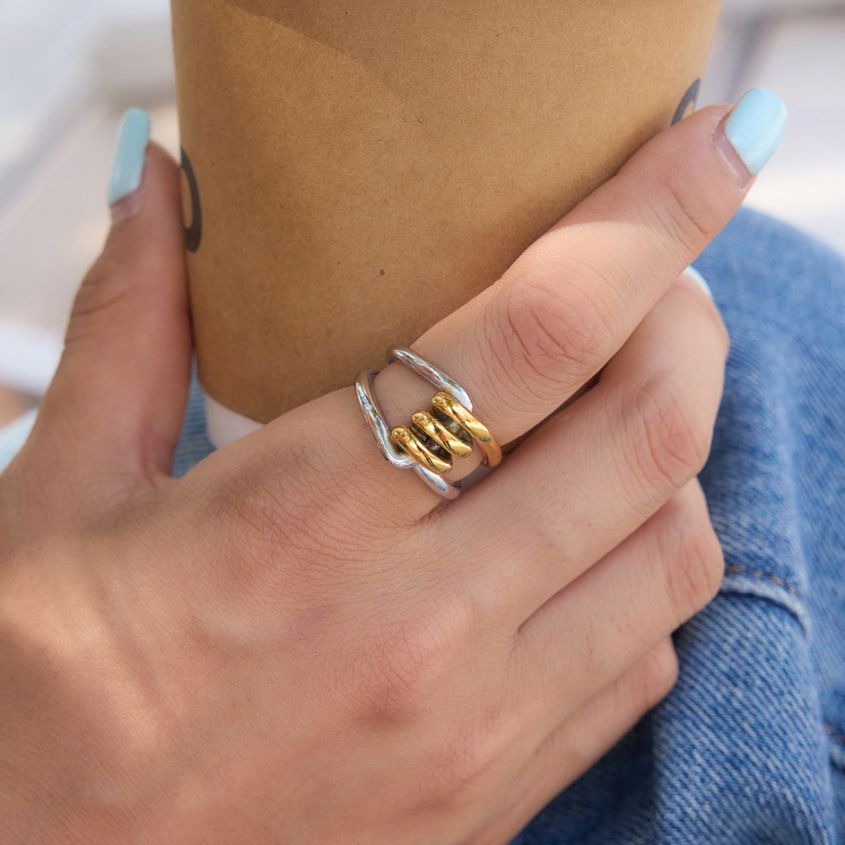 Interlinked gold and silver-tone ring worn on a finger