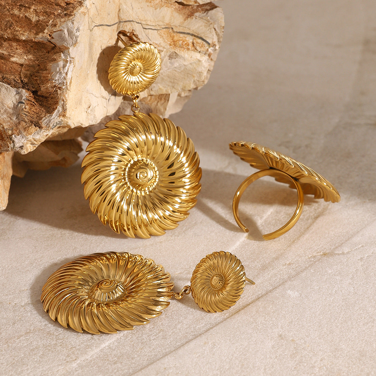 Spiral disc drop earrings displayed with a separate ring reference