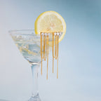 pair of clear-stone chain tassel earrings on a cocktail glass