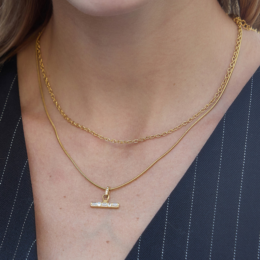 Layered link and snake chains worn at the neckline