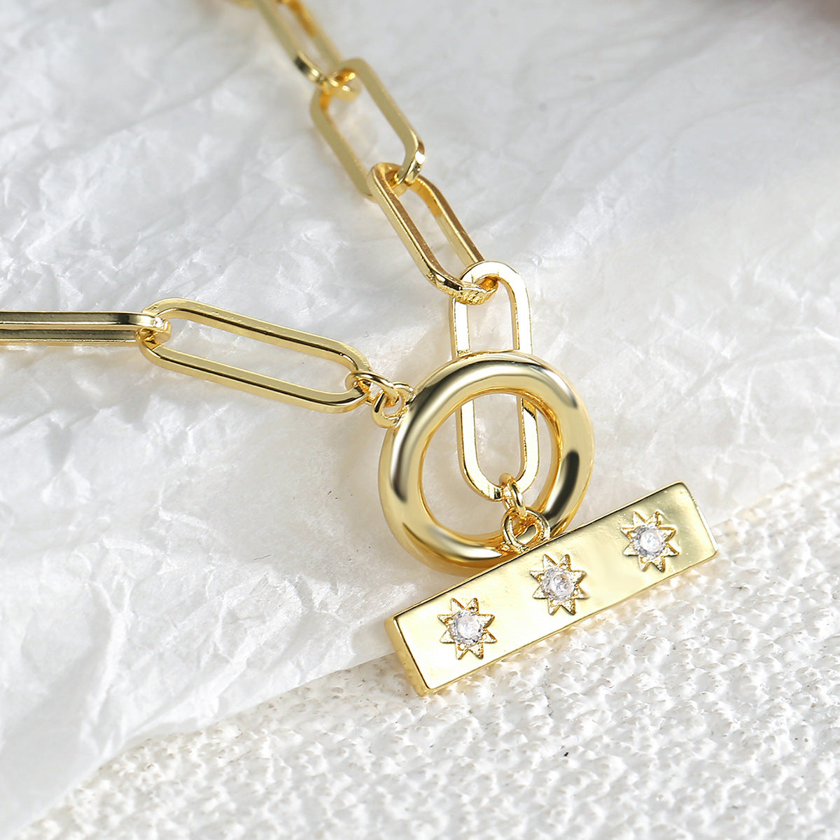 close view of the round toggle and three-zirconia bar pendant