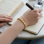 Heart-link bracelet layered with a fine chain bracelet