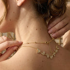 Butterfly necklace shown across a model's shoulder with clasp visible