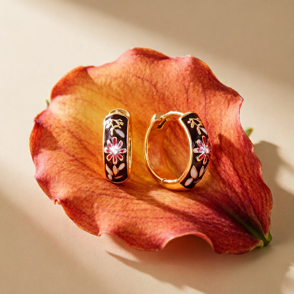 Pair of brown floral hoops resting on a flower petal
