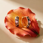 Pair of brown floral hoops resting on a flower petal